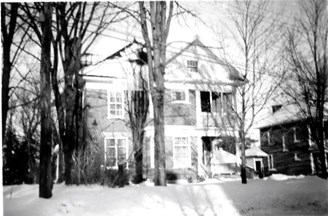 Handford Family home in Renfrew. Two storey home with white trim and large trees. Picture taken during winter, snow visible on the ground.